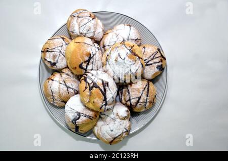 Hausgemachte Schokolade Crinkles Cookies Puderzucker auf weißen Hintergründen. Draufsicht . Hausgemachte Schokolade crinkles auf einem weißen quadratischen Teller. Stockfoto