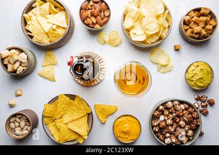 Veraity Schüsseln mit Biersnacks und Soßen auf Steintisch. Nüsse, Chips, Nachos, Cracker. Draufsicht mit Copyspace Stockfoto