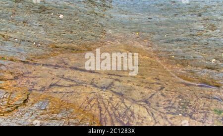 Felsen, Kieselsteine, Felsenpools, Sand und Meer an einem bewölkten Junitag in Cornwall Stockfoto