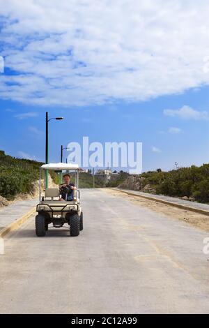 Mann mit dem Golfauto am Meer. Mexiko. Women Island. Stockfoto