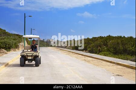 Mann mit dem Golfauto am Meer. Mexiko. Women Island. Stockfoto