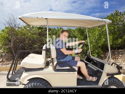 Mann mit dem Golfauto am Meer. Mexiko. Stockfoto