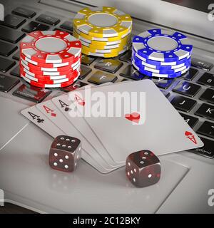 Laptop mit Chips, Würfel und Poker-Karten Stockfoto