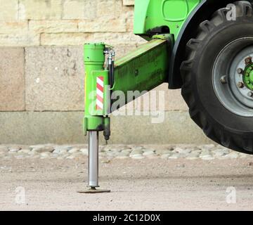 LKW starke Stützen stabilisierende Beine verlängert. Boom hebt Baustoffmaschinen auf dem Dach des Palastes Stockfoto