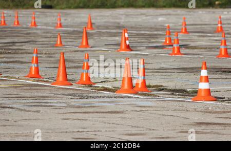 Kunststoff-Signalkegel stehen auf dem Gelände, wo die Fahrer die Prüfung der richtigen Lkw fahren. Stockfoto