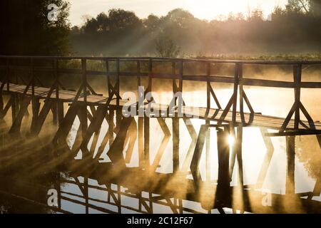 Holzbrücke auf dem Meer bei Sonnenaufgang Stockfoto