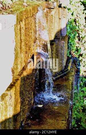 Wasser fließt an einer schmutzigen Wand entlang Stockfoto