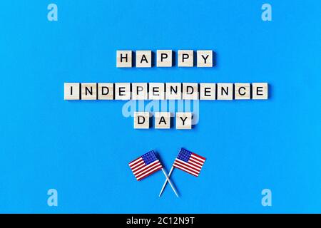 Happy Independence Day Inschrift in Holzbuchstaben auf blauem Hintergrund. Alles Gute Zum Unabhängigkeitstag. Der 4. Juli. USA Unabhängigkeitstag. Amerikanische Flockbeine Stockfoto