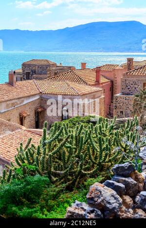 Monemvasia Kirche, alte Häuser aus rotem Backstein, Dächer in der Altstadt und dem blauen Meer, Peloponnes, Griechenland. Traditionelle griechische Architektur Hintergrund Stockfoto