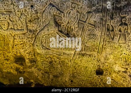 Die Royston Cave in Herfordshire, Großbritannien, verwirrt heute noch Historiker. Die Figur ganz links auf dem Bild mit den erhobenen Armen könnte König David aus dem Buch der Psalmen sein. Der linke Arm, der gebogen ist, um ein Quadrat zu bilden, könnte ebenso ein Zeichen ähnlich dem Fellow Craft-Grad des Mauerwerks sein. Royston Cave in Katherine's Yard, Melbourn Street, Royston, England Stockfoto