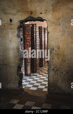 Loch in einer Wand, die in einen Raum mit Zellen im S21 Tuol Sleng Gefängnis Genozid Museum Phnom Penh Kambodscha führt Stockfoto