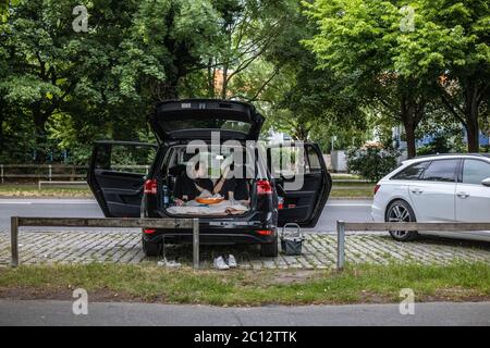 Junge Erwachsene, die ein Picknick im Hinterwagen am Maschsee, Hannover, machen Stockfoto