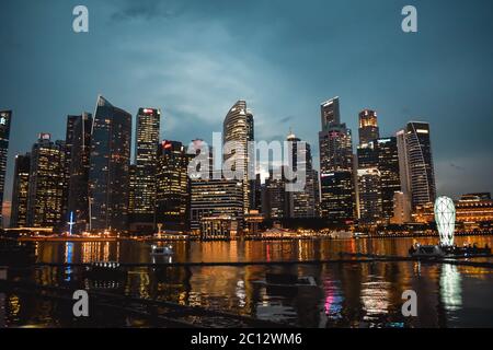 Dämmerung Foto des beleuchteten Singapur Handelsviertel im Wasser der Marine Bay reflektiert Stockfoto