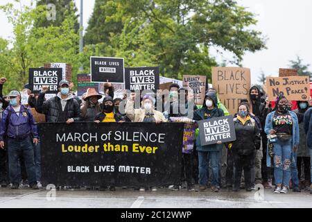 Der Vorsitzende von Black Lives Matter, Ebony Miranda (in gelb), führt Anhänger in einem stillen marsch durch den Zentralbezirk von Seattle am Freitag, den 12. Juni 2020. Tausende von Unterstützern trotzten heftigen Regenfällen, um an dem landesweiten Schweigemmarsch und dem Generalstreik teilzunehmen. Black Lives Matter Seattle-King County organisierte den landesweiten Aktionstag und einen stillen marsch, um die verlorenen Leben zur Unterstützung aller Schwarzen im Staat Washington zu ehren. Stockfoto