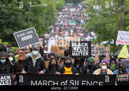 Der Vorsitzende von Black Lives Matter, Ebony Miranda (in gelb), führt Anhänger in einem stillen marsch durch den Zentralbezirk von Seattle am Freitag, den 12. Juni 2020. Tausende von Unterstützern trotzten heftigen Regenfällen, um an dem landesweiten Schweigemmarsch und dem Generalstreik teilzunehmen. Black Lives Matter Seattle-King County organisierte den landesweiten Aktionstag und einen stillen marsch, um die verlorenen Leben zur Unterstützung aller Schwarzen im Staat Washington zu ehren. Stockfoto