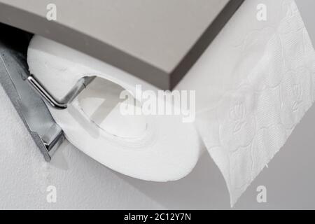 Toilettenpapierrolle an der Wand des modernen weißen Badezimmers Stockfoto