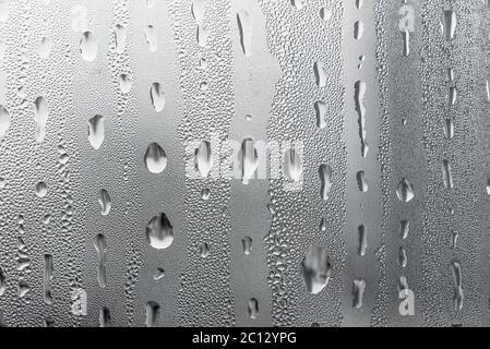 Makrofotografie Wasser Tropfen auf Glasfenster weißen Hintergrund nach dem Regen. Stockfoto