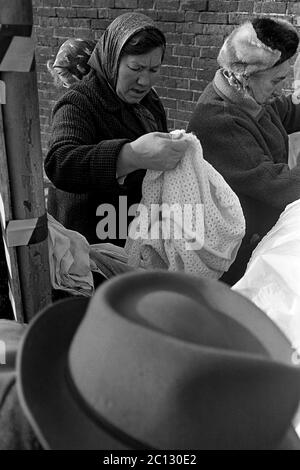 AJAXNETPHOTO. FEBRUAR 1975. PORTSMOUTH, ENGLAND. - FLOHMARKT - IN DER UNICORN ROAD; KÄUFER STÖBERN DURCH GEBRAUCHTE WAREN UND KLEIDUNG AUF DEM BÜRGERSTEIG.FOTO:JONATHAN EASTLAND/AJAX REF:7513 31A 115 Stockfoto