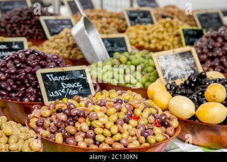 Provenzalische Mischung aus Oliven (Melange provenzalisch auf Französisch) in Holzschale auf dem Lebensmittelmarkt in Paris Stockfoto