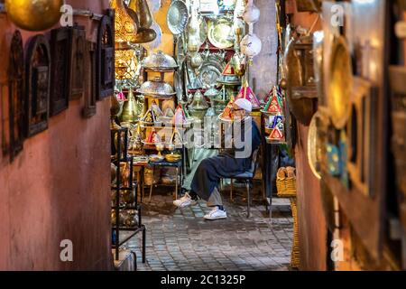 Marrakesch, Marokko: Ein schmaler Alleway in der Medina mit Geschäften oder Souks verkaufen Beleuchtung und Wohnkultur Objekte beleuchtet Stockfoto