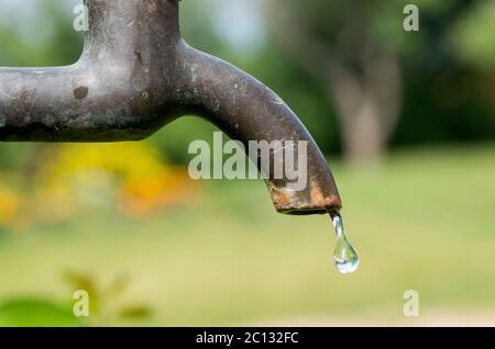 Eine alte rostige Wasserhahn im Garten. Stockfoto