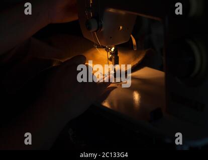 Die Hand der Frau, die an einer Nähmaschine arbeitet Stockfoto