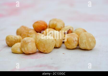 Natürlich aussehende geröstete Haselnüsse. Köstliche Bündel von gerösteten Nüssen auf einem Tisch, frisch geschälte Haselnüsse. Eine Handvoll Lebensmittel Zutaten für ein gesundes Dessert Stockfoto