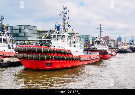Leistungsstarke Schlepper, die an einem Steg in einem Flusshafen festgemacht haben. Hamburg, Deutschland Stockfoto