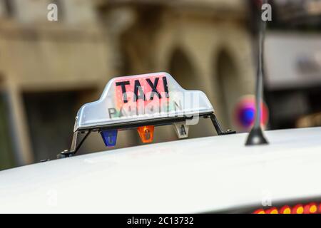 Pariser Taxi auf der Avenue des champs-elysees, mit dem Arc de Triomphe und Verkehr im Hintergrund Stockfoto