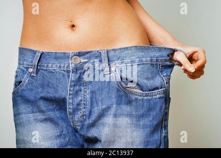 Frau mit zu großen Jeans nach einer Diät Stockfoto