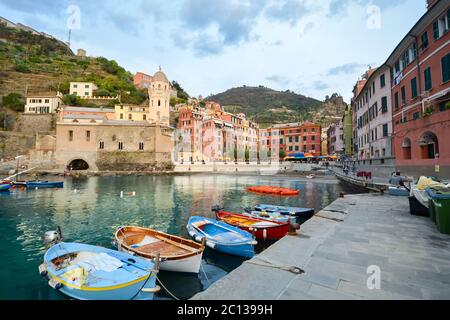 Boote fahren am kleinen Hafen des malerischen Dorfes Vernazza, Italien, eines der Dörfer der Cinque Terre in der ligurischen Region Italiens. Stockfoto