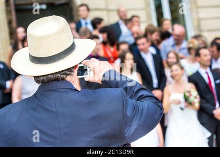 Gast, der während der Hochzeit ein Foto von der Familie mit seinem Telefon gemacht hat Stockfoto