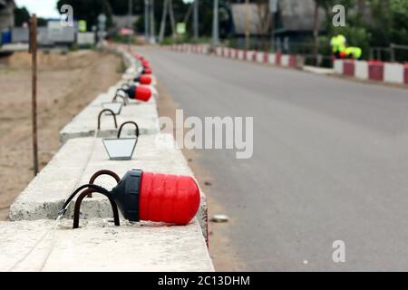 Signalleuchten auf den grundlegenden Blöcke aus Beton, Zaunbau das Viadukt von der bestehenden Straße. Stockfoto