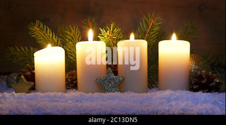 Vier brennende Adventskerzen und Weihnachtsdekoration. Stockfoto