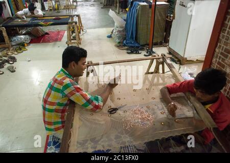 DHAKA, BANGLADESCH 2. Juli : Arbeiter näht sich einen Mantel zum Verkauf vor dem Eid Al Fitr Festival in Dhaka am 02. Juli 2015. Ramadan ist der größte Spendin Stockfoto