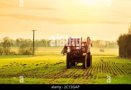 Traktor bereitet sich darauf vor, Pestizide auf einem Feld zu sprühen Stockfoto