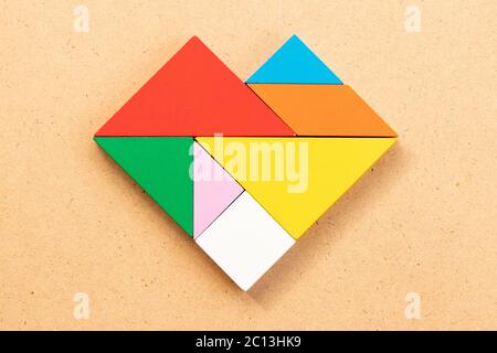 Farbe Tangram Puzzle in Herzform auf Holz bacground Stockfoto