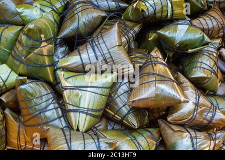 Heap of ZhongZi - traditionelle chinesische Reisgericht aus klejezem Reis gefüllt und in Bambusblätter in einem Straßenmarkt, Chengdu, Provinz Sichuan, China eingewickelt Stockfoto