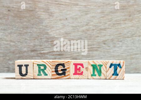 Alphabet Buchstaben Block in Wort dringend auf Holz Hintergrund Stockfoto