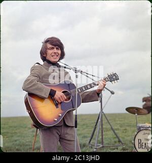 George Harrison führt "I need you" auf dem Filmset VON HILFE! Gefilmt auf Salisbury Plain, Wiltshire. Mai 1964. Bild aus 6x6 cm Transparenz. Stockfoto