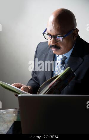 Männlicher Manager, der sich im Heimbüro Notizen gemacht hat. Forschung Stock Foto Stockfoto