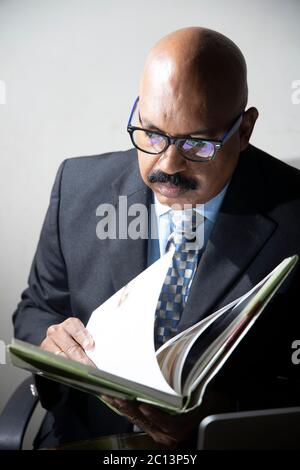 Männlicher Manager, der sich im Heimbüro Notizen gemacht hat. Forschung Stock Foto Stockfoto