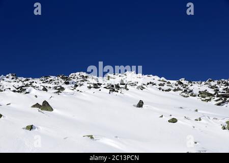 Felsige Bergspitze im Schnee Stockfoto