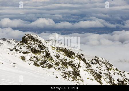 Felsige schneebedeckte Berggipfel Wolken Stockfoto