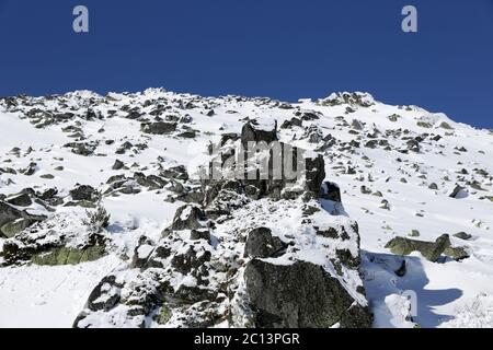 Felsiger schneebedeckter Berggipfel Stockfoto