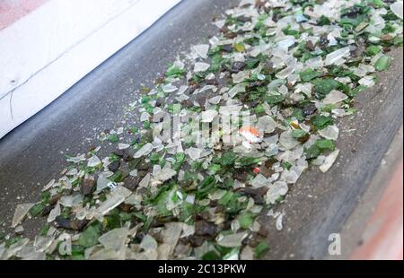 Glasabfälle in der Recyclinganlage. Glaspartikel in einer Maschine Stockfoto