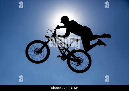Silhouette mit Fahrradsprung Stockfoto