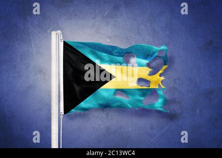 Zerrissene Flagge der Bahamas, die vor grunge Hintergrund fliegt Stockfoto