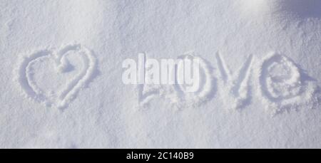 Herzform und Liebeswort im Schnee geschrieben. Stockfoto