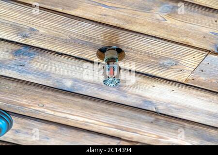 Sprinkler an der braunen Holzdecke eines Gebäudes oder Hauses installiert Stockfoto